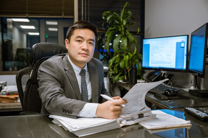 Professional attorney in suit at desk examining legal papers and computer screens for temporary disability benefits in California workers compensation cases